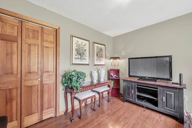 sitting room with a textured ceiling and hardwood / wood-style flooring