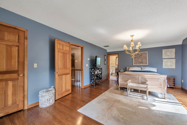 interior space with a textured ceiling, hardwood / wood-style floors, and a chandelier