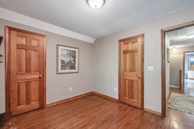 unfurnished bedroom with wood-type flooring and a textured ceiling