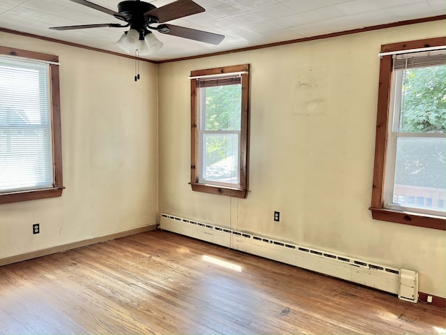 empty room featuring ceiling fan, light hardwood / wood-style flooring, baseboard heating, and a healthy amount of sunlight