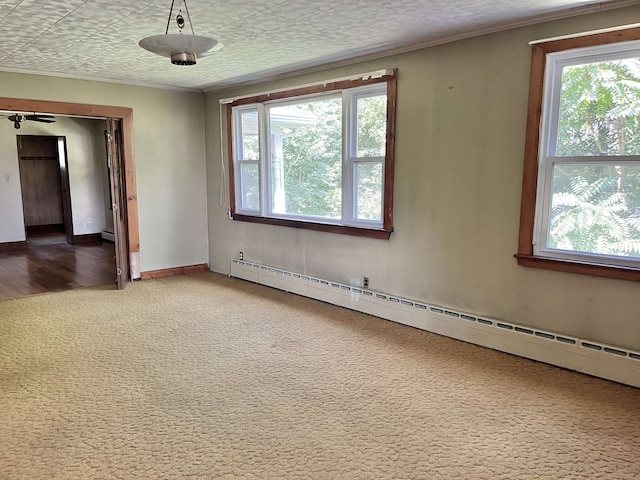 carpeted spare room featuring a textured ceiling and a baseboard heating unit