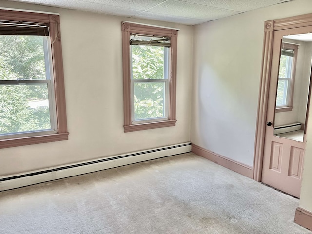 spare room featuring light carpet and a baseboard heating unit