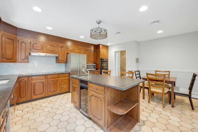 kitchen featuring backsplash, a kitchen island, sink, and stainless steel appliances