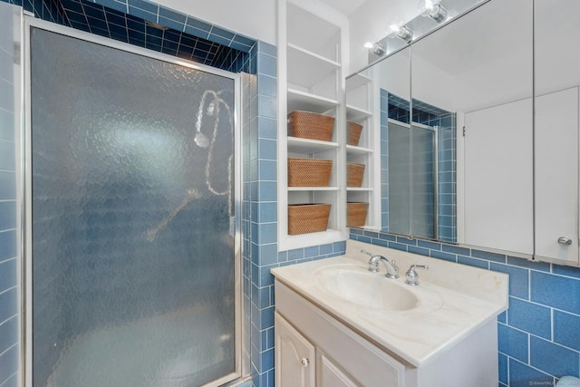 bathroom with tile walls, backsplash, walk in shower, and vanity