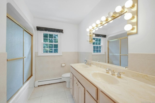 full bathroom with baseboard heating, toilet, tile walls, and a healthy amount of sunlight