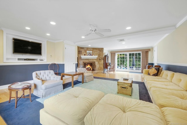 living room featuring ceiling fan, hardwood / wood-style flooring, a fireplace, and ornamental molding