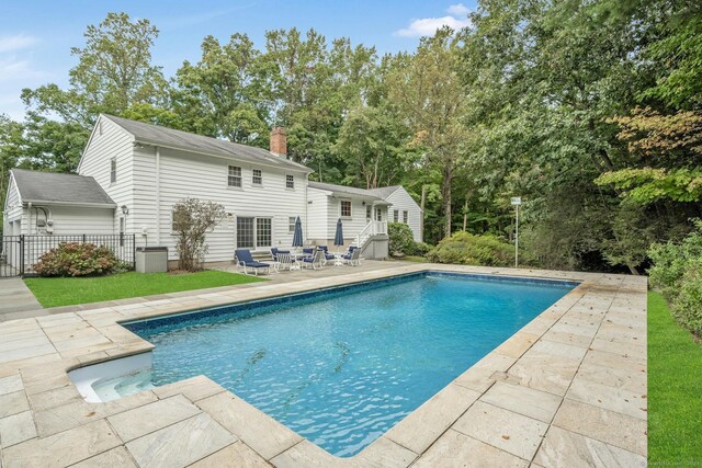 view of pool featuring cooling unit and a patio area