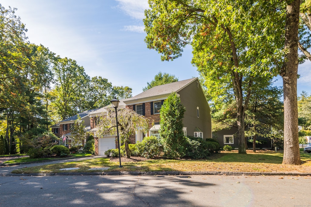 colonial-style house with a front yard and a garage