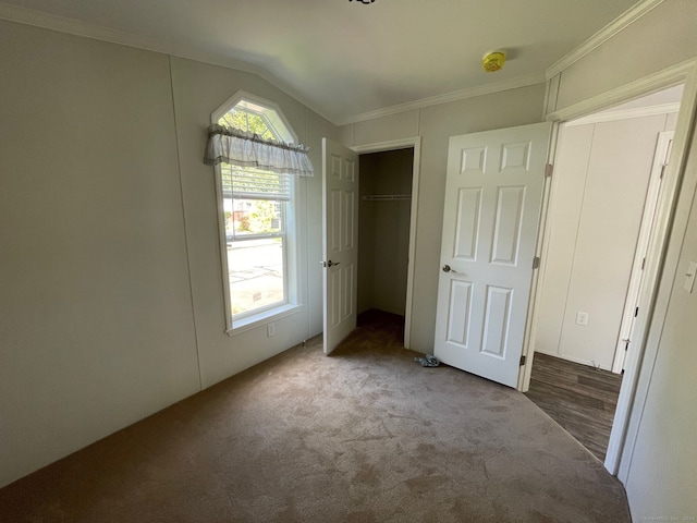 unfurnished bedroom featuring carpet, lofted ceiling, and crown molding