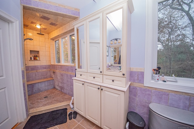 bathroom with tile walls, a shower, toilet, and tile patterned flooring