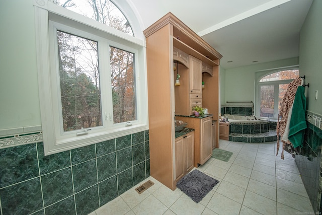 bathroom featuring a tub, a healthy amount of sunlight, and tile patterned flooring