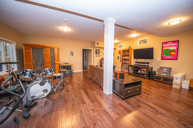 living room featuring dark wood-type flooring and decorative columns