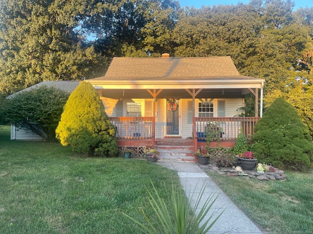 bungalow with covered porch and a front yard