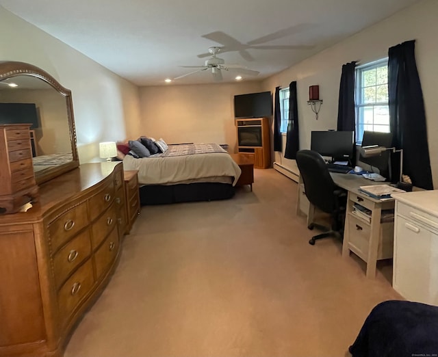 carpeted bedroom featuring a baseboard radiator and ceiling fan