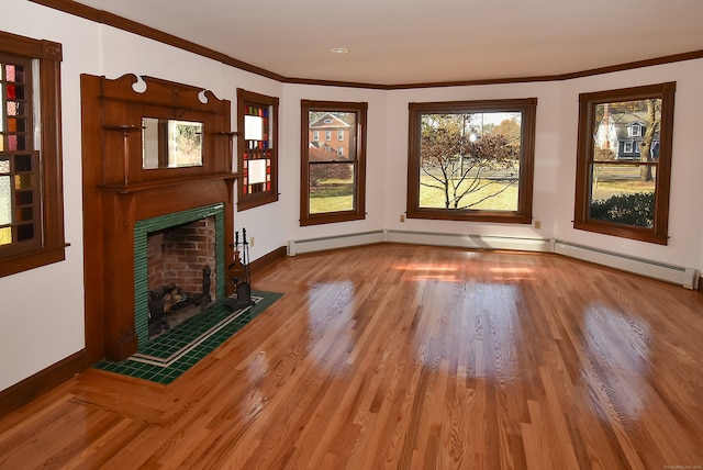 unfurnished living room featuring a tile fireplace, wood-type flooring, a baseboard heating unit, and ornamental molding