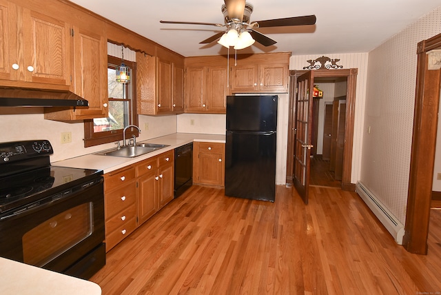 kitchen with black appliances, sink, ceiling fan, a baseboard radiator, and light hardwood / wood-style floors