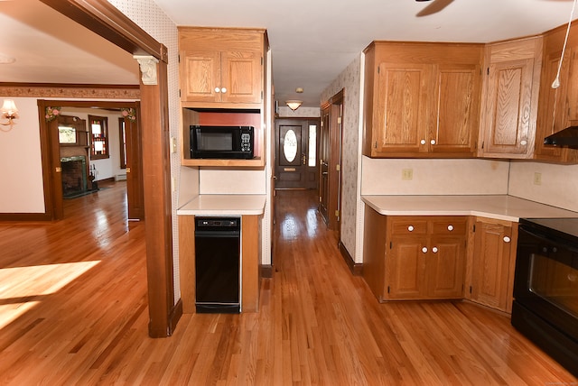 kitchen featuring black appliances, custom exhaust hood, and light hardwood / wood-style floors