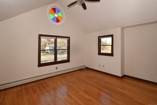 empty room featuring ceiling fan, light hardwood / wood-style floors, vaulted ceiling, and a baseboard heating unit