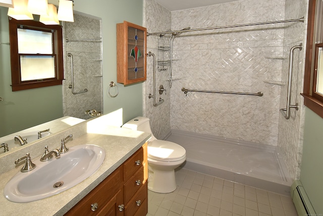 bathroom featuring vanity, baseboard heating, tiled shower, tile patterned flooring, and toilet