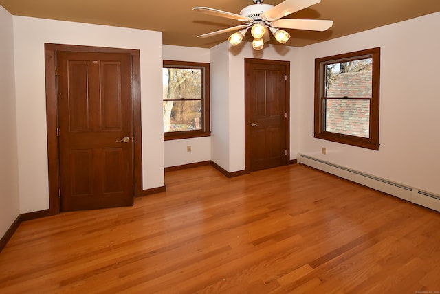 unfurnished bedroom with ceiling fan, light wood-type flooring, and a baseboard radiator