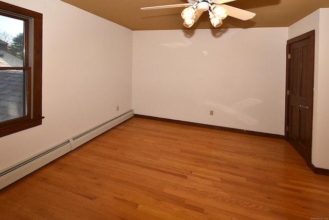 unfurnished room featuring light hardwood / wood-style flooring, ceiling fan, and a baseboard heating unit