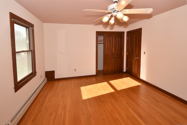 unfurnished room featuring ceiling fan, light hardwood / wood-style floors, and baseboard heating