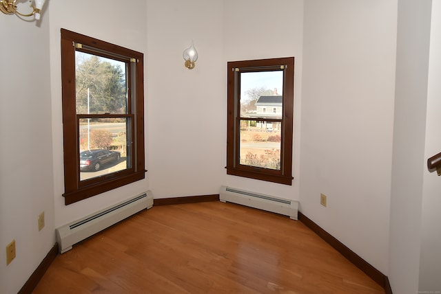 spare room with light hardwood / wood-style floors, plenty of natural light, and baseboard heating