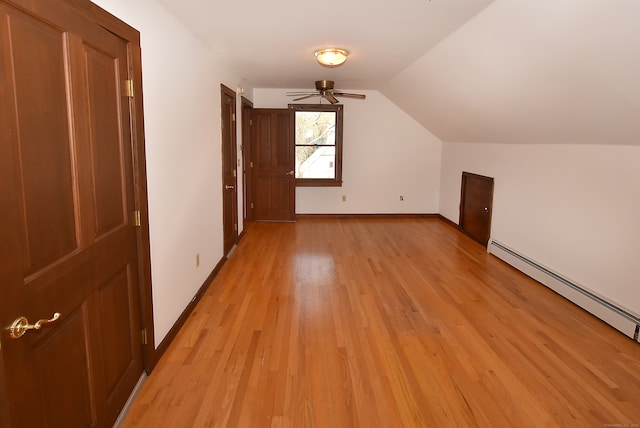 additional living space with light hardwood / wood-style floors, a baseboard radiator, ceiling fan, and lofted ceiling