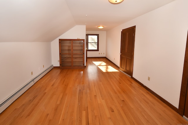 bonus room featuring baseboard heating, light hardwood / wood-style flooring, and vaulted ceiling