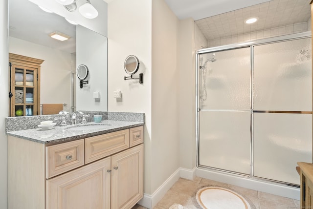 bathroom featuring vanity, a shower with shower door, and tile patterned flooring