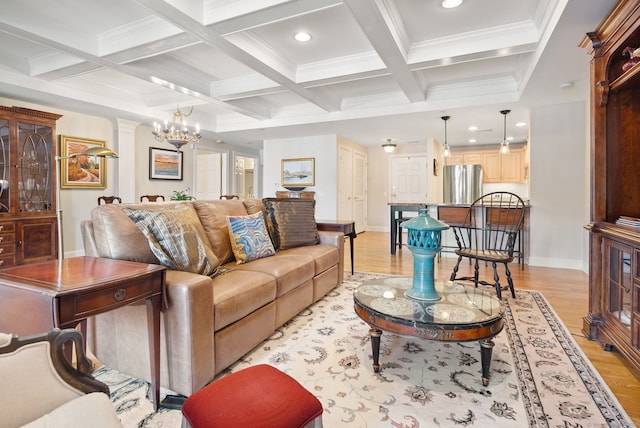 living room featuring a notable chandelier, light hardwood / wood-style floors, coffered ceiling, and beamed ceiling