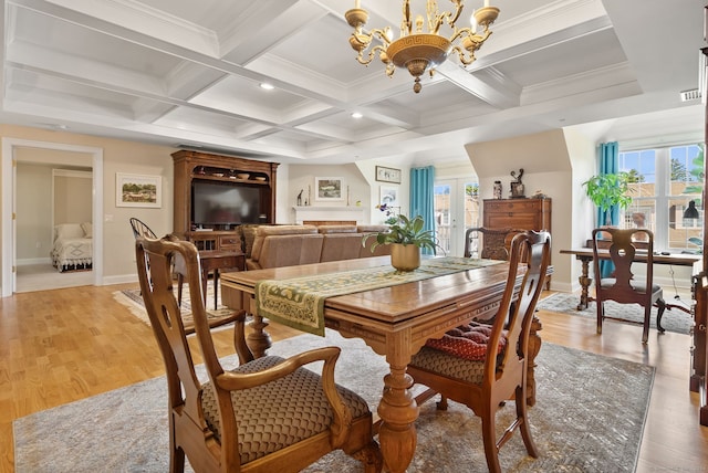 dining room with beam ceiling, light wood-type flooring, ornamental molding, a notable chandelier, and coffered ceiling