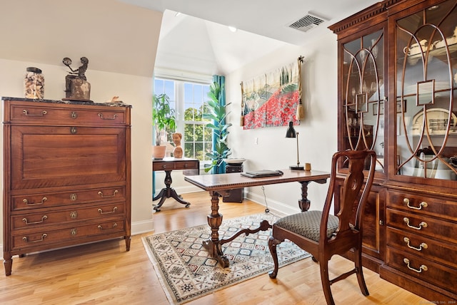 home office with lofted ceiling and light hardwood / wood-style floors