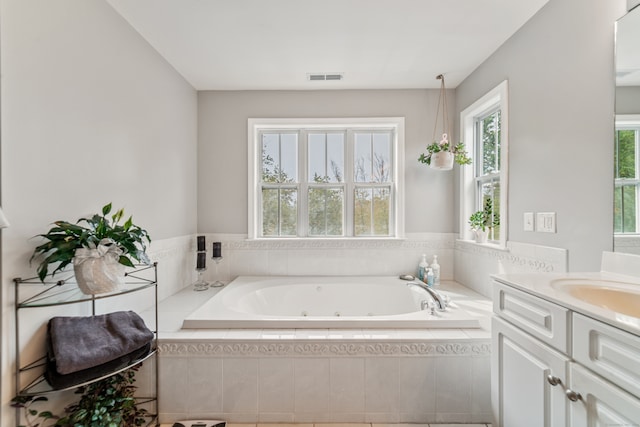 bathroom featuring vanity and a relaxing tiled tub