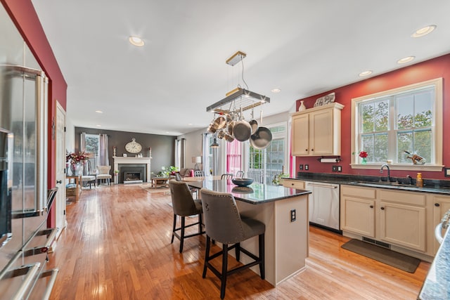 kitchen with dishwasher, light hardwood / wood-style flooring, sink, and a wealth of natural light