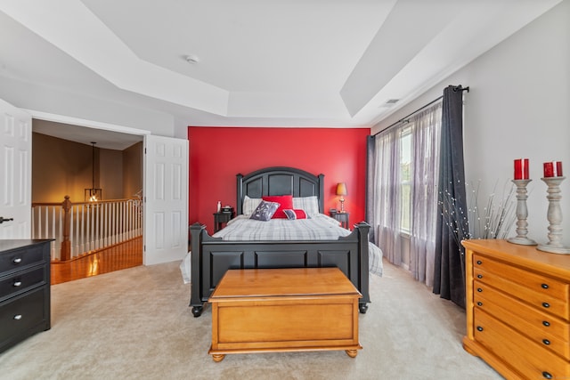 carpeted bedroom featuring a tray ceiling