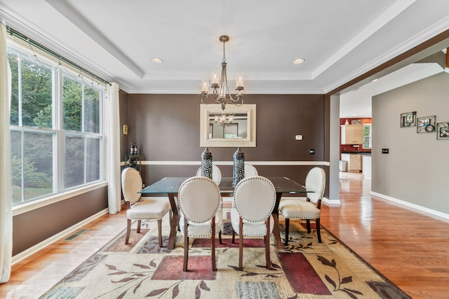 dining room featuring light hardwood / wood-style floors, a tray ceiling, and plenty of natural light