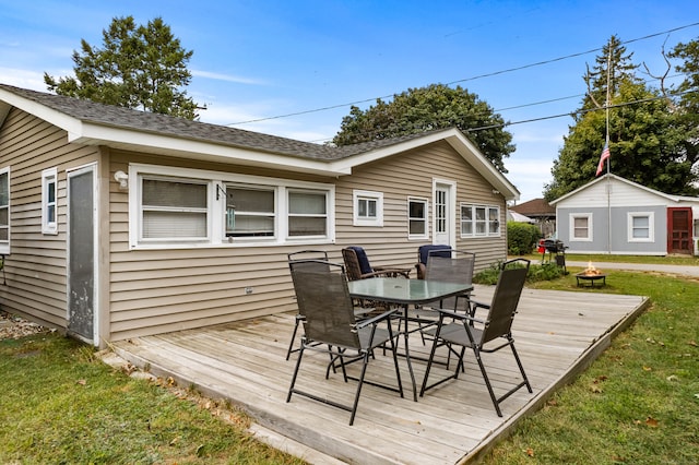 deck with a lawn, a grill, and an outbuilding