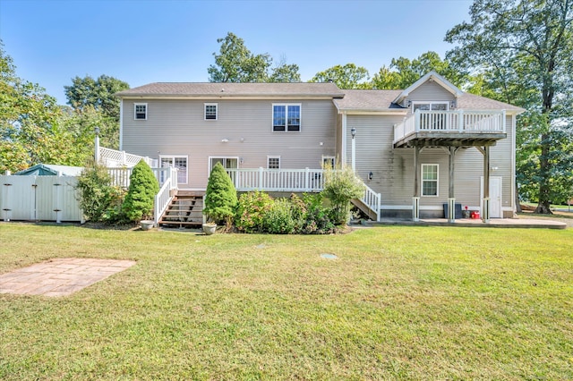 rear view of house featuring a lawn and a deck