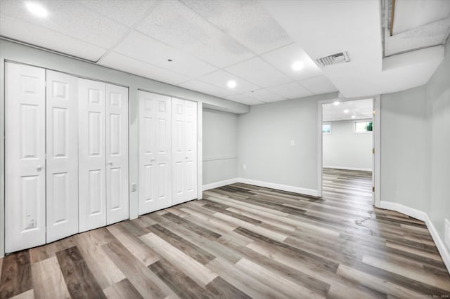 basement featuring a drop ceiling and hardwood / wood-style floors