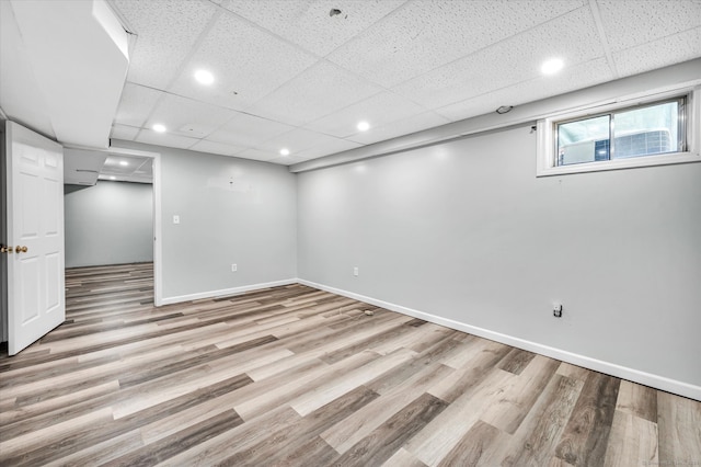 basement with light hardwood / wood-style floors and a drop ceiling