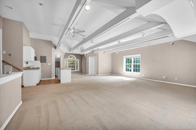 unfurnished living room featuring lofted ceiling with beams, electric panel, ceiling fan, sink, and light carpet