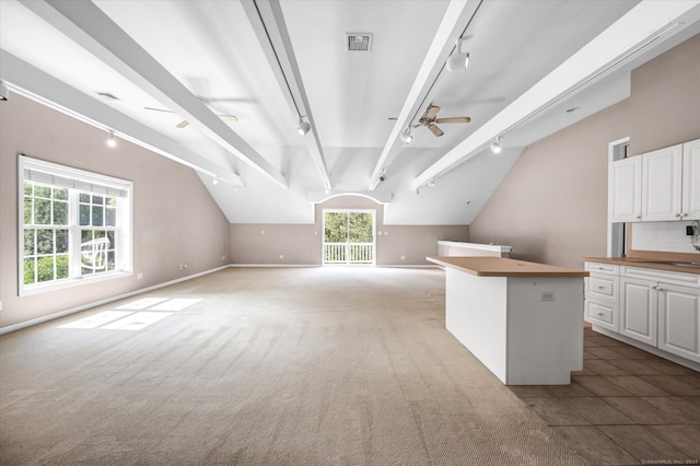 interior space with light tile patterned floors, lofted ceiling with beams, sink, and ceiling fan