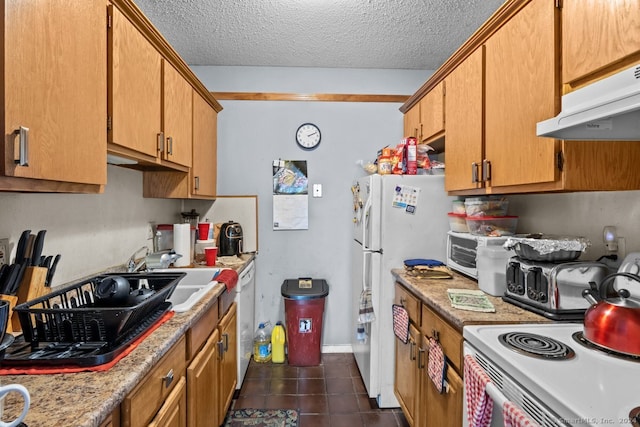 kitchen with a textured ceiling, white appliances, range hood, and dark tile patterned floors