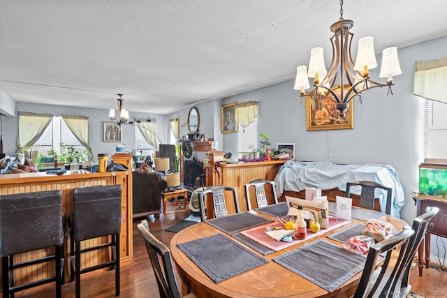 dining room featuring an inviting chandelier, wood-type flooring, and a textured ceiling