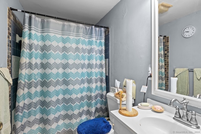 bathroom featuring curtained shower, vanity, and toilet