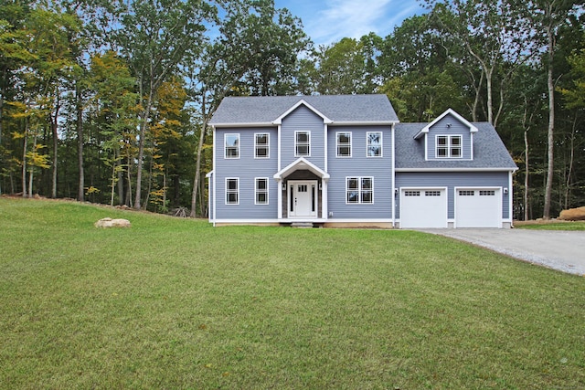 colonial house featuring a garage and a front lawn