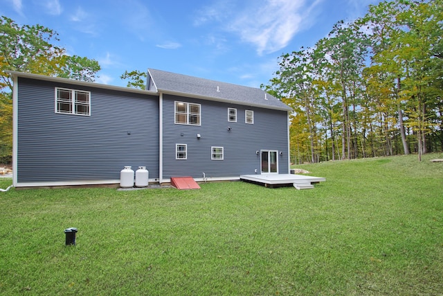 back of house with a wooden deck and a lawn