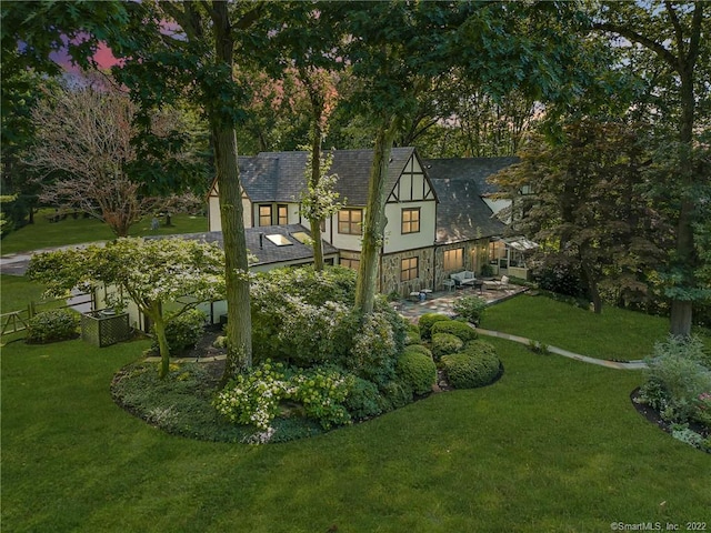 view of front of house featuring a lawn and a patio area