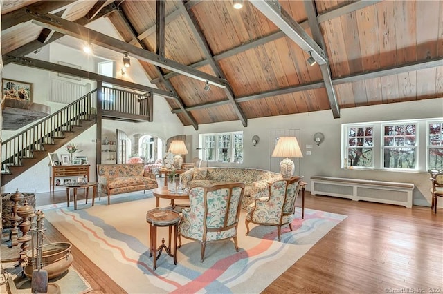 living room featuring high vaulted ceiling, radiator heating unit, beamed ceiling, wooden ceiling, and hardwood / wood-style floors